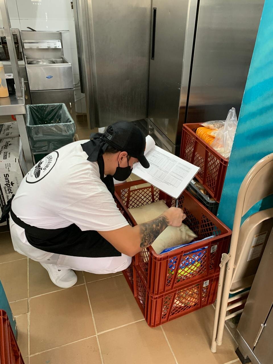 Colaborador de Submarino Express con uniforme de la marca haciendo inventario de insumos en la cocina